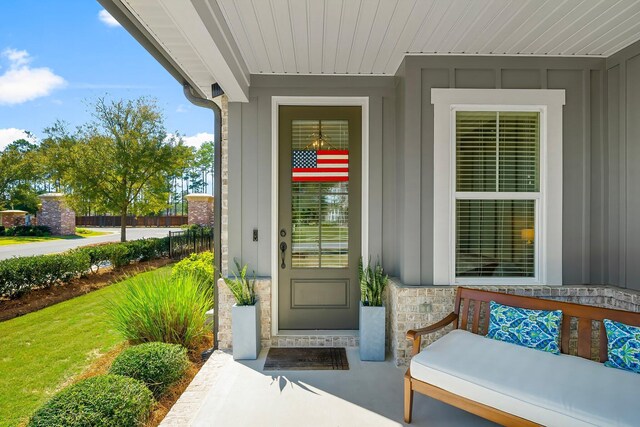 view of exterior entry with board and batten siding and stone siding
