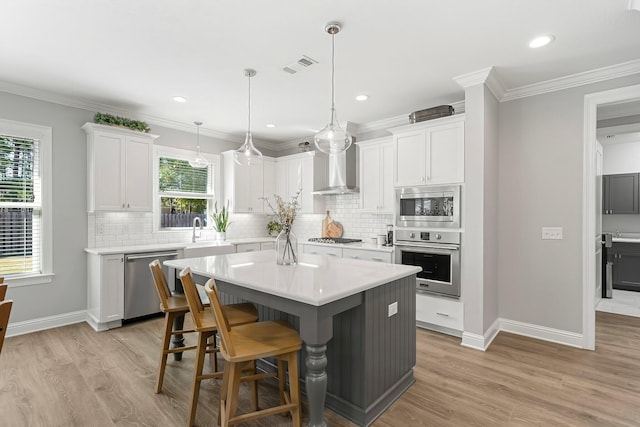 kitchen featuring a center island, visible vents, light wood-style flooring, and stainless steel appliances