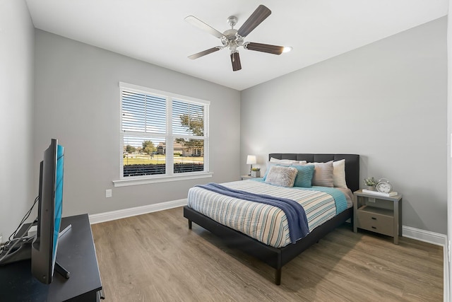 bedroom featuring baseboards, wood finished floors, and ceiling fan