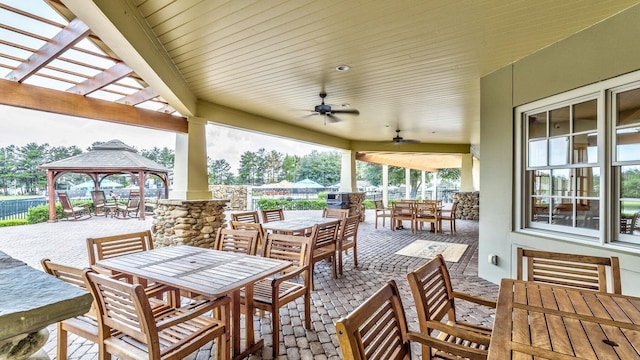 view of patio / terrace with fence, a gazebo, outdoor dining area, a ceiling fan, and a pergola