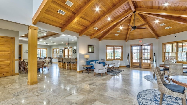 living area with beamed ceiling, visible vents, baseboards, and wood ceiling