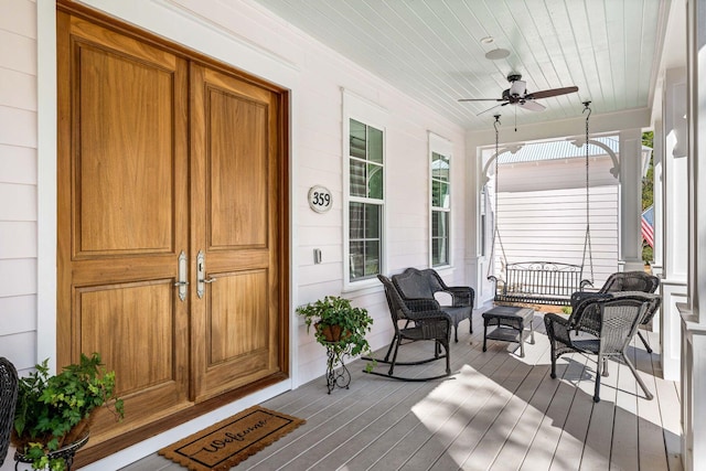 wooden terrace featuring a porch and a ceiling fan