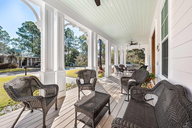 wooden terrace with a ceiling fan and covered porch