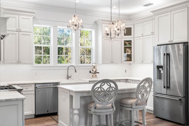 kitchen featuring visible vents, a sink, wood finished floors, white cabinetry, and stainless steel appliances