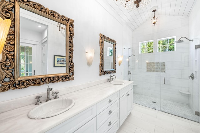 bathroom featuring double vanity, a stall shower, lofted ceiling, and a sink