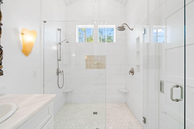 bathroom with vanity, vaulted ceiling, and a shower stall