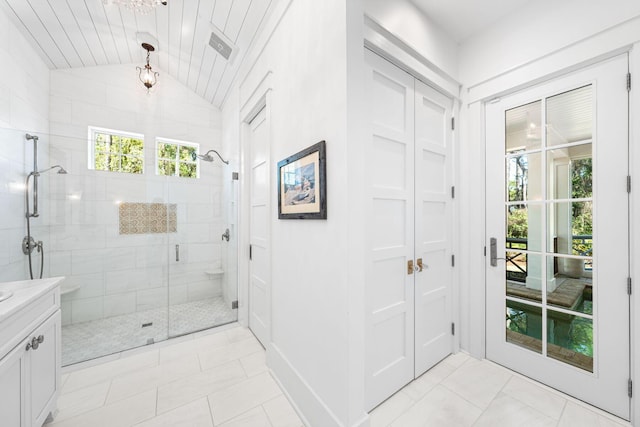 bathroom featuring vanity, a shower stall, and vaulted ceiling