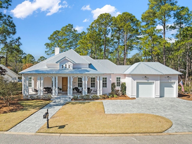 view of front of house with a garage, decorative driveway, a porch, and a front yard