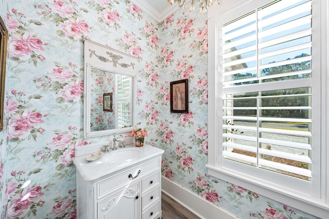 bathroom with wallpapered walls, plenty of natural light, vanity, and baseboards