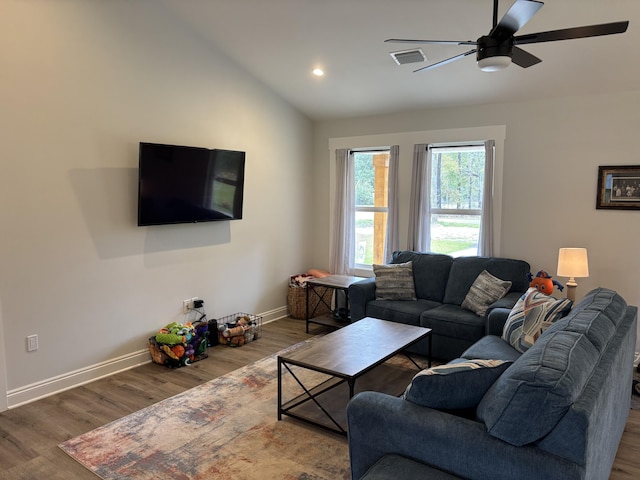 living room featuring visible vents, baseboards, lofted ceiling, wood finished floors, and a ceiling fan