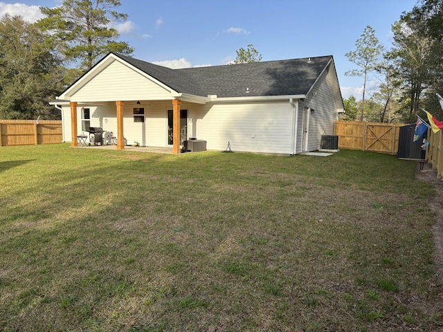 rear view of house with fence private yard, central AC unit, a yard, a patio area, and a gate