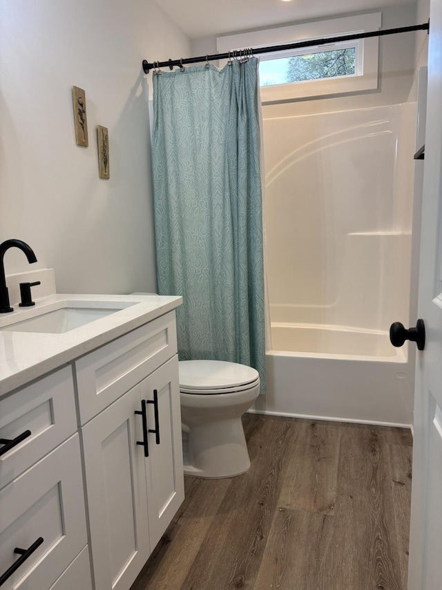 full bath featuring vanity, toilet, wood finished floors, and shower / tub combo with curtain