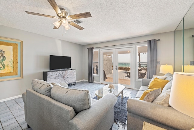 living area with visible vents, ceiling fan, french doors, tile patterned floors, and a textured ceiling