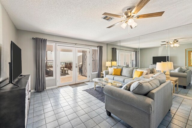 living room featuring visible vents, ceiling fan, french doors, a textured ceiling, and tile patterned floors