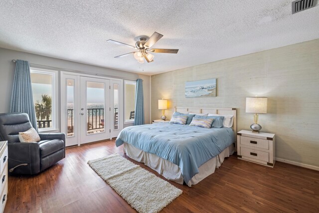 bedroom featuring wood finished floors, baseboards, visible vents, access to exterior, and a textured ceiling