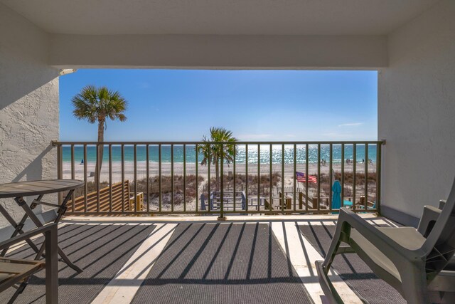 balcony featuring a water view and a view of the beach