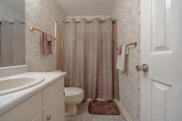 bathroom featuring a textured ceiling, toilet, vanity, and wallpapered walls