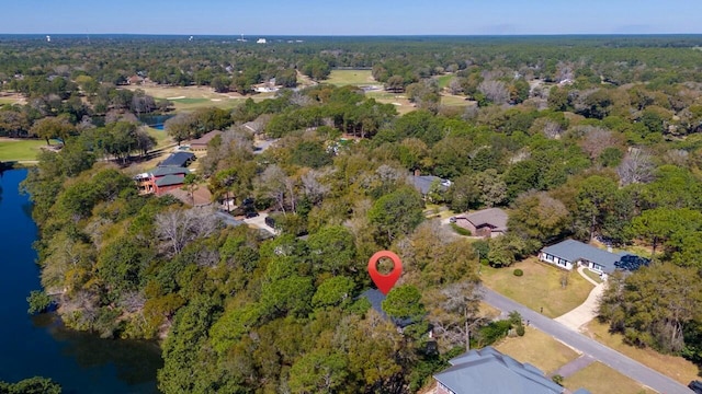 birds eye view of property featuring a forest view and a water view