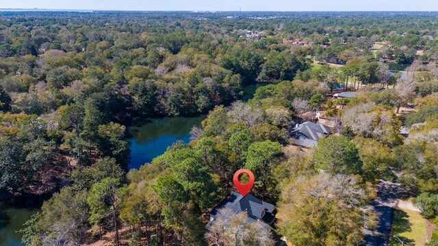 birds eye view of property with a wooded view and a water view