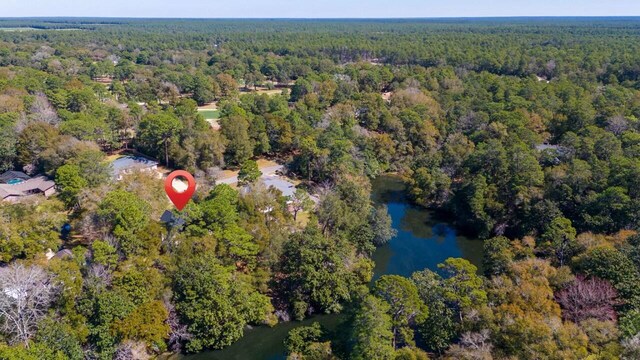 birds eye view of property featuring a forest view and a water view