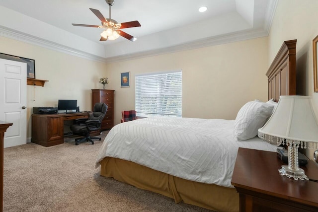 bedroom featuring ceiling fan, a tray ceiling, crown molding, and light carpet