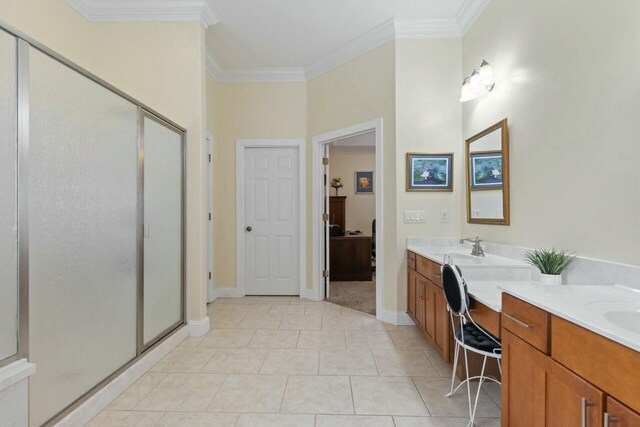 bathroom featuring double vanity, tile patterned flooring, a shower stall, and ornamental molding