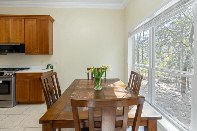 dining space featuring light tile patterned floors and crown molding