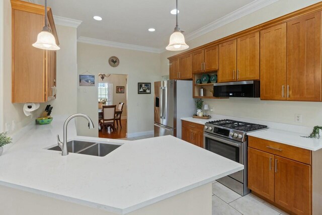 kitchen with ornamental molding, appliances with stainless steel finishes, a peninsula, brown cabinetry, and a sink