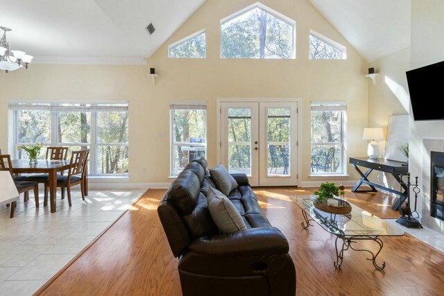 living room with a wealth of natural light, french doors, a fireplace with flush hearth, and visible vents