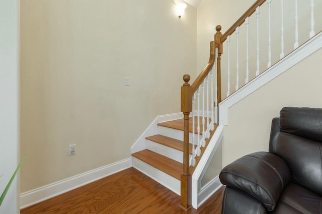 stairs featuring wood finished floors and baseboards