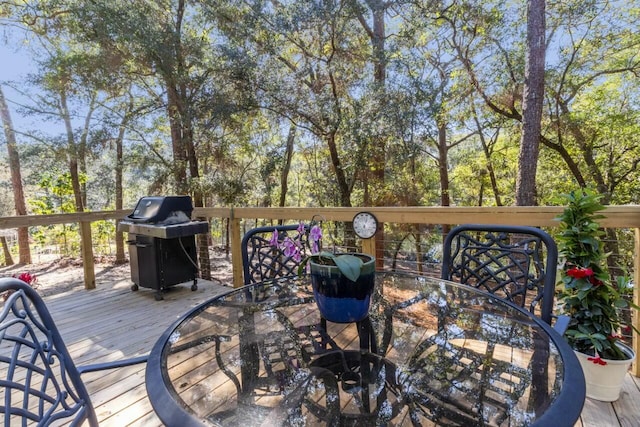 wooden deck with outdoor dining space and a grill