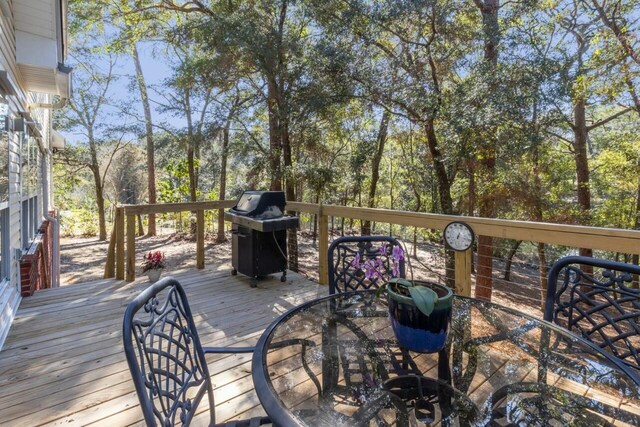 wooden terrace featuring area for grilling and outdoor dining area