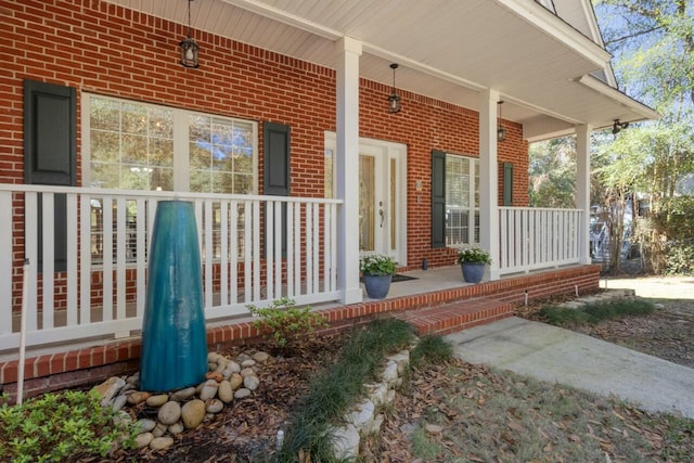 entrance to property with brick siding and covered porch