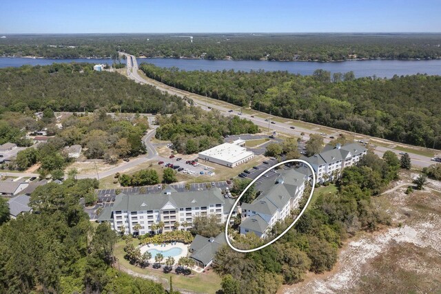 aerial view featuring a forest view and a water view