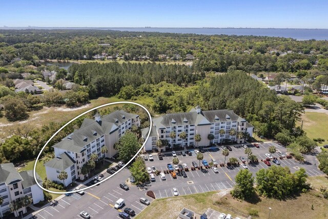 birds eye view of property with a water view and a wooded view