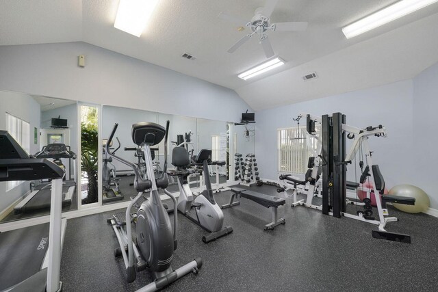 workout area with vaulted ceiling, a ceiling fan, and visible vents