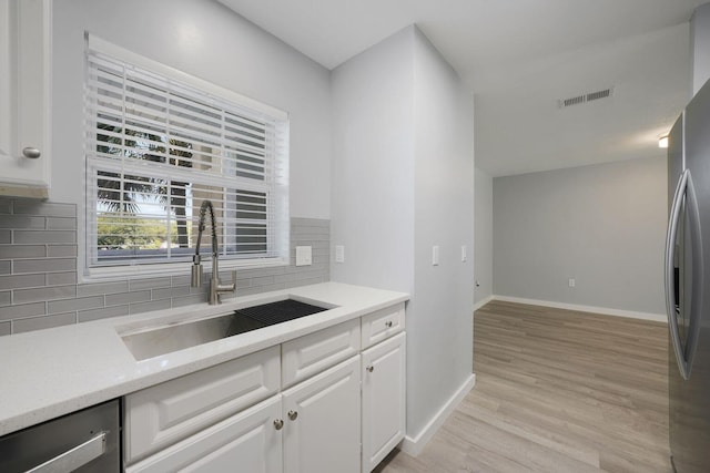 kitchen featuring visible vents, a sink, light countertops, appliances with stainless steel finishes, and light wood-type flooring