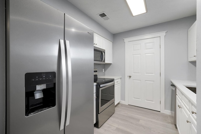 kitchen featuring white cabinetry, light countertops, visible vents, and appliances with stainless steel finishes