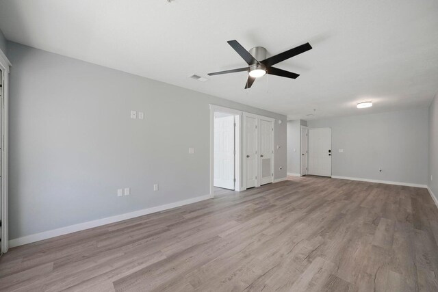 interior space with visible vents, baseboards, light wood-style floors, and a ceiling fan