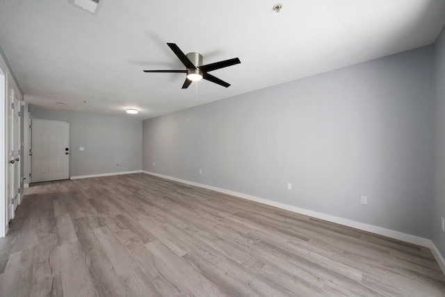 spare room with ceiling fan, visible vents, baseboards, and wood finished floors