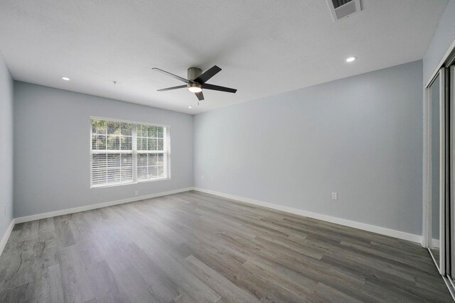 unfurnished room featuring visible vents, baseboards, and wood finished floors