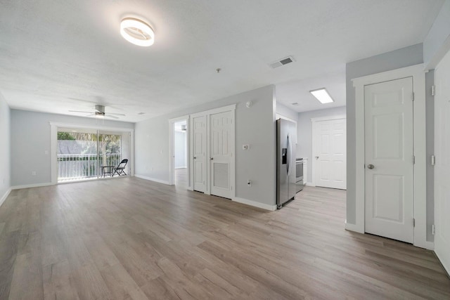 unfurnished living room with visible vents, baseboards, light wood-style floors, and a ceiling fan