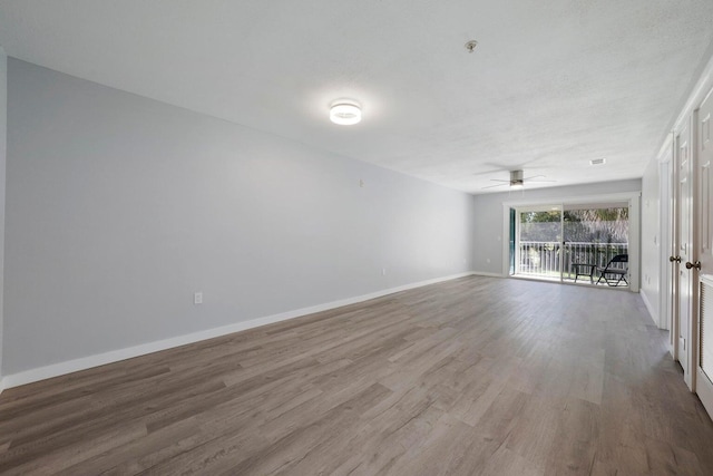 spare room with ceiling fan, baseboards, and wood finished floors