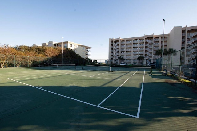 view of tennis court featuring fence