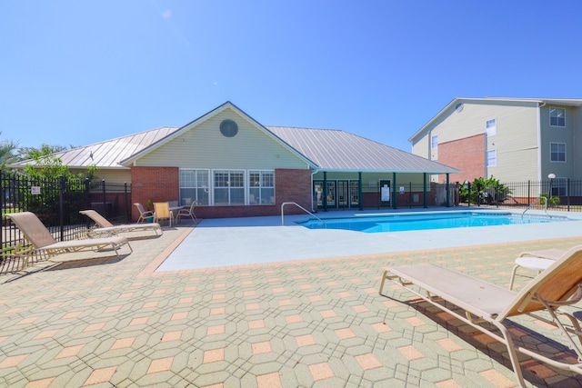 community pool featuring a patio area and fence