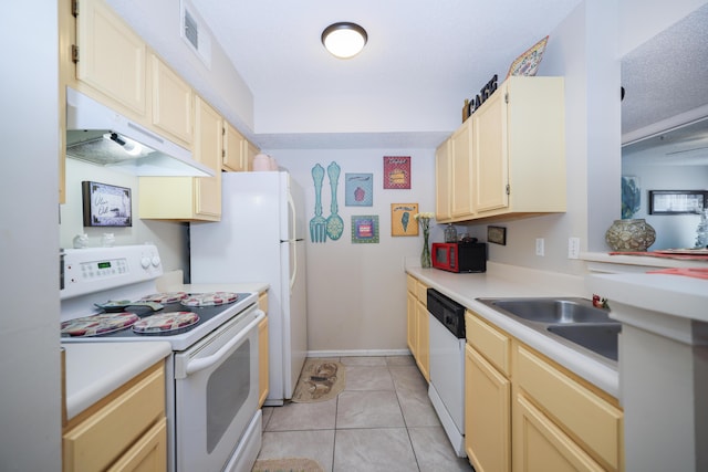 kitchen with white appliances, light tile patterned floors, a sink, light countertops, and under cabinet range hood