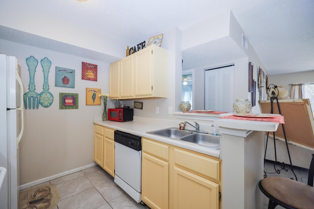 kitchen with white appliances, light tile patterned floors, visible vents, a sink, and light countertops