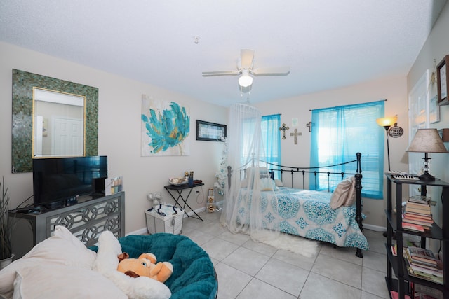 tiled bedroom featuring a ceiling fan and baseboards