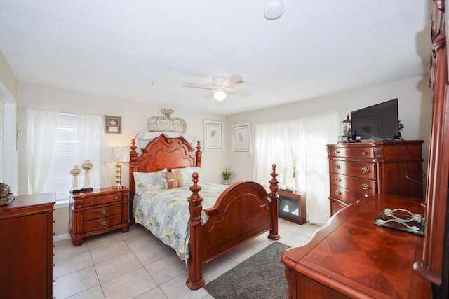 bedroom featuring multiple windows, light tile patterned flooring, and ceiling fan