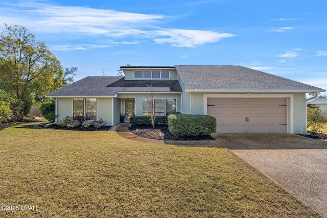 view of front of property with an attached garage, concrete driveway, a front lawn, and a shingled roof